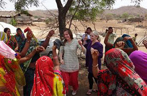 caucasian woman in Indian garb dancing with locals