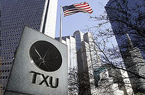 TXU logo on austere sign against skyscraper building